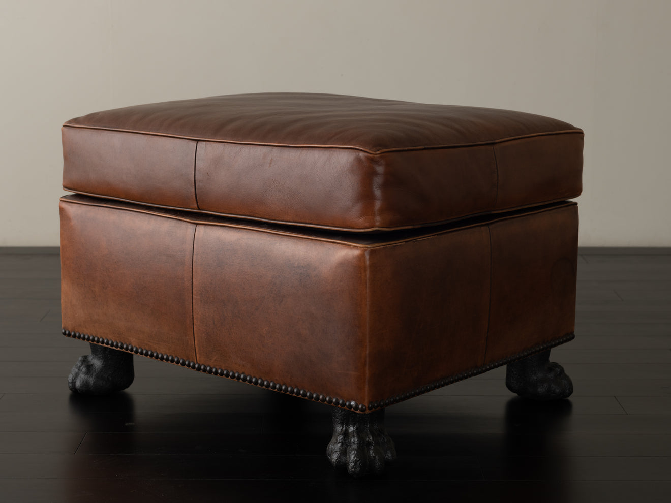 BRONZE FOOTED LEATHER OTTOMAN
